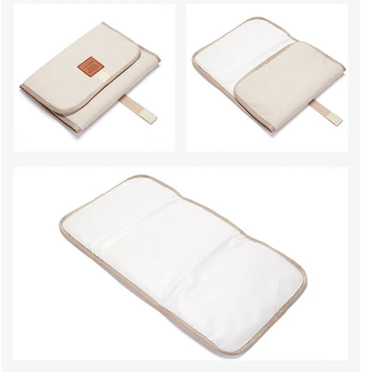 Cream foldable baby changing mat showing folded, partially open, and fully unfolded waterproof interior.