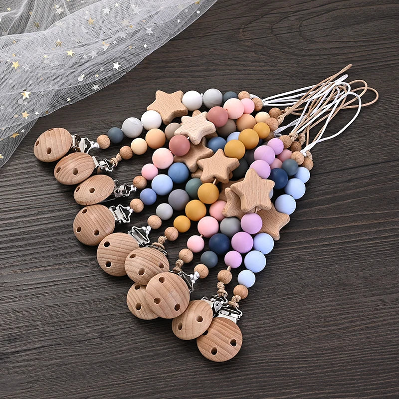 Set of ten wood and silicone pacifier clip chains with star-shaped beads and pastel round silicone beads.