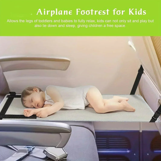 Toddler resting on gray kids airplane foot hammock installed on airplane seat.