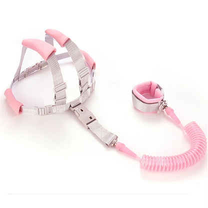 Pink toddler anti-lost safety harness with 2m spring leash wrist strap laid flat.