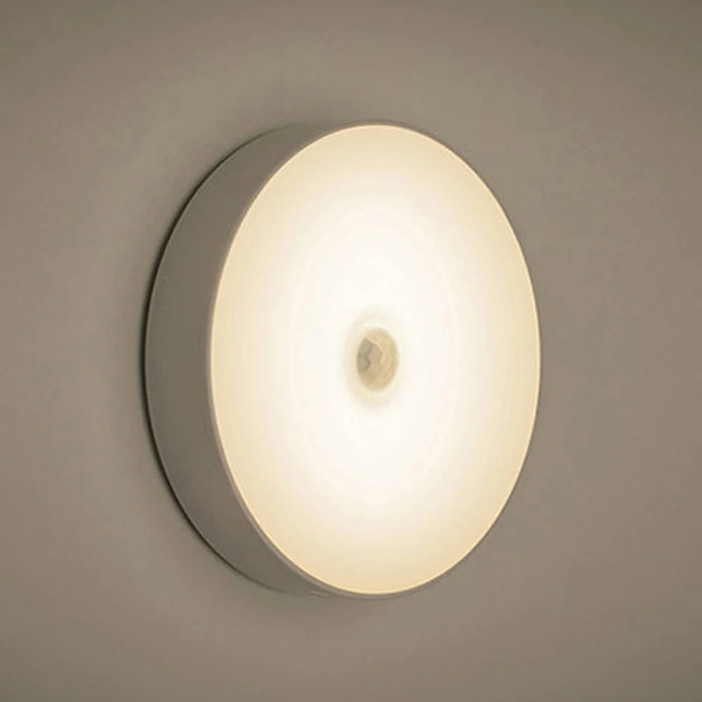Warm light rechargeable motion sensor night light glowing softly on wall.