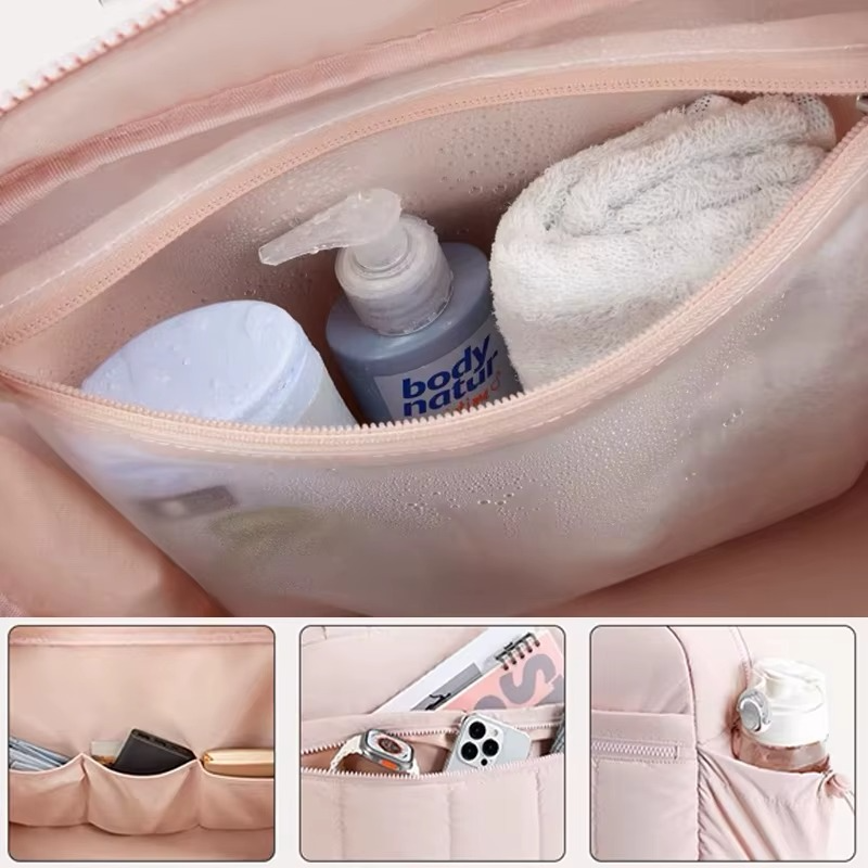 Interior of pink waterproof diaper travel bag with zippered compartment holding baby essentials and organizer pockets.