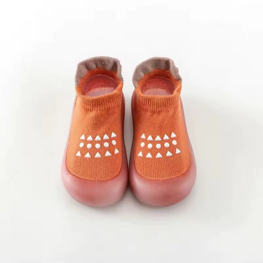 Orange breathable baby walking shoes with soft sole and white anti-slip pattern front view.