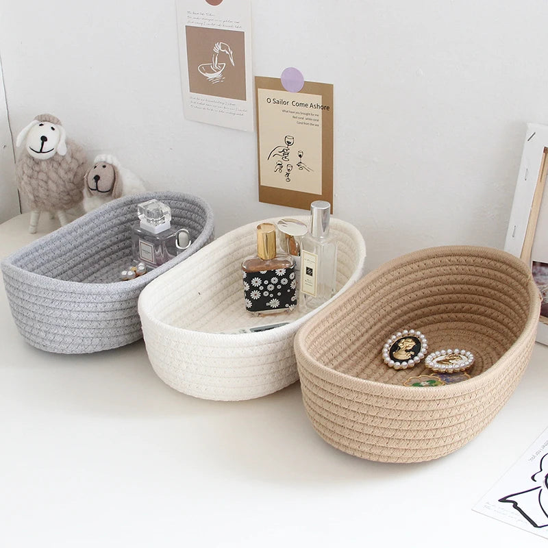 Set of three woven cotton rope storage baskets in grey, white, and khaki for nursery or desktop organization.