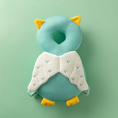 Mint Owl breathable mesh baby head protection pillow backpack with white wings and yellow feet, flat lay.