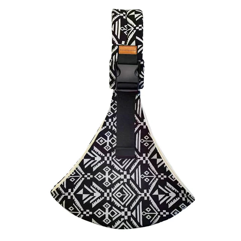 Black and white geometric patterned adjustable baby carrier wrap flat lay with buckle and strap.