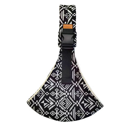 Black and white geometric patterned adjustable baby carrier wrap flat lay with buckle and strap.