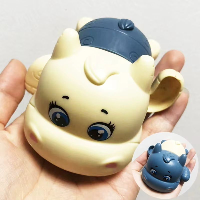 Lake blue calf wind-up bath toy held in hand showing face and body.