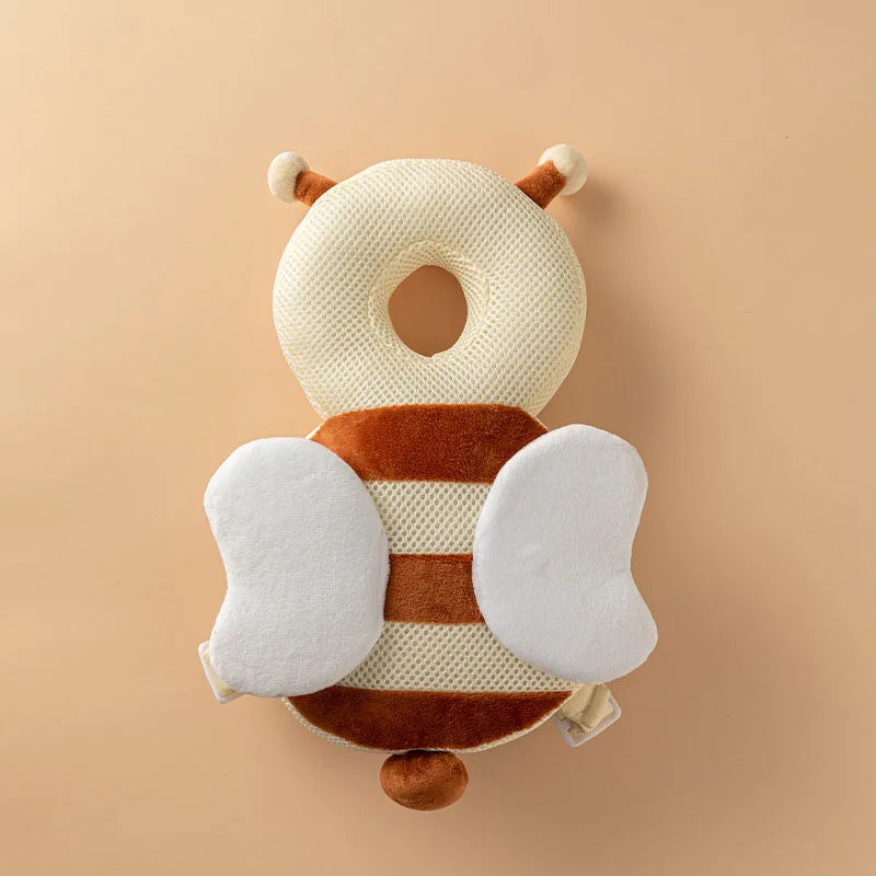 Bee Plush baby head protection pillow backpack with white wings and antennae, flat lay.