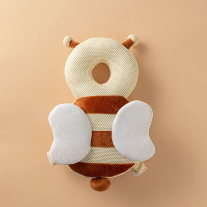 Bee Plush baby head protection pillow backpack with white wings and antennae, flat lay.