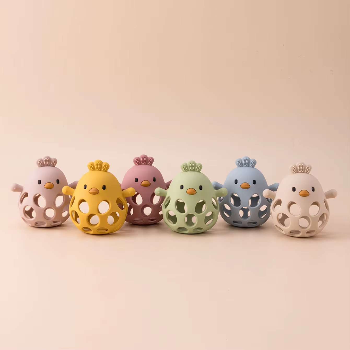 Set of six silicone baby teether rattles in assorted colors lined up.