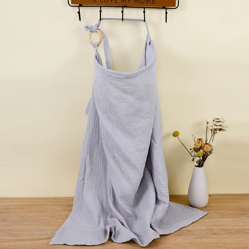 Gray blue breathable muslin nursing cover hanging with adjustable strap and wooden ring.