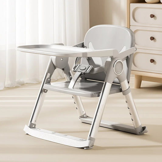 Gray portable baby booster seat with tray folded out, adjustable high chair for baby feeding.