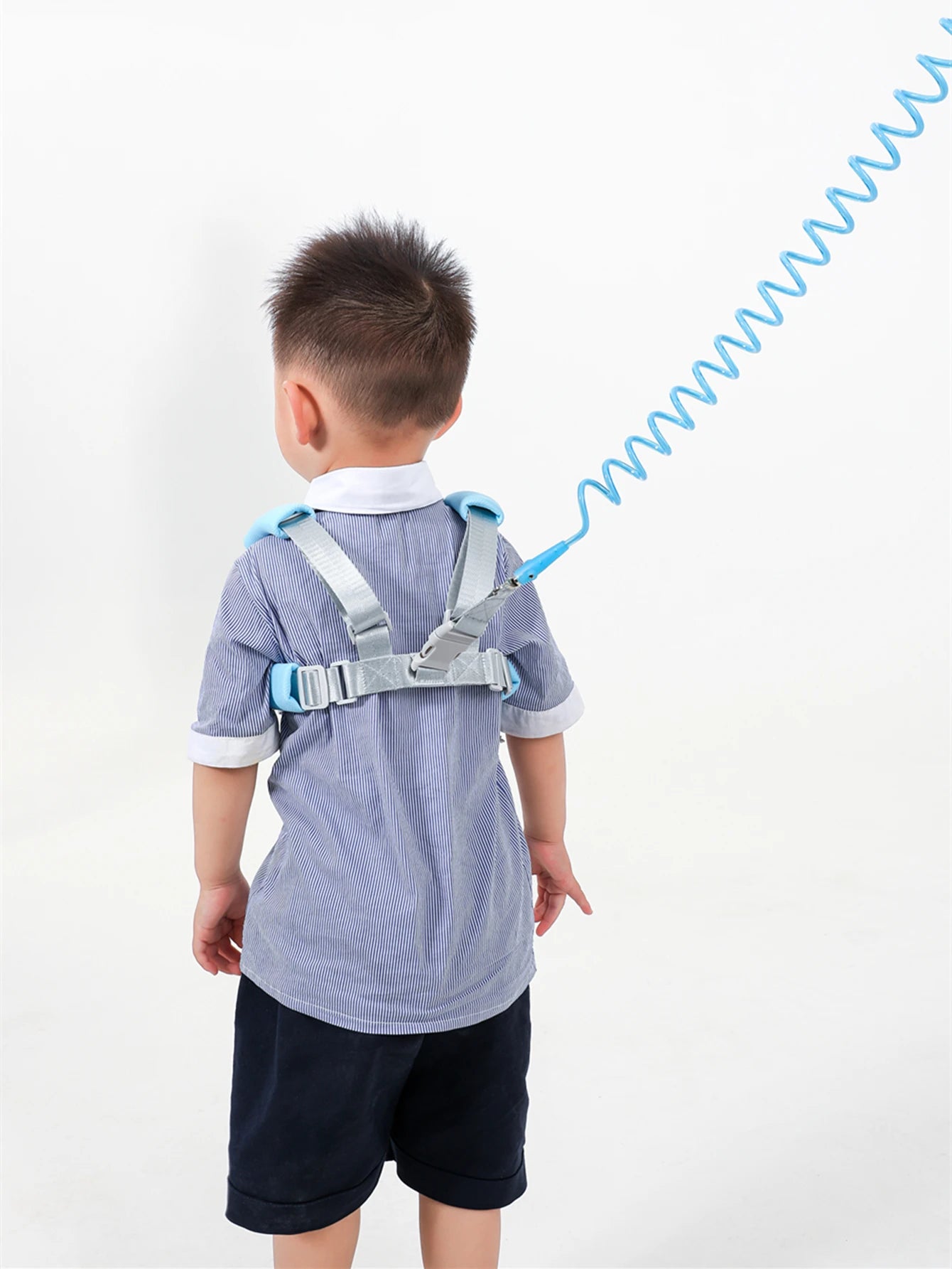 Back view of toddler wearing blue anti-lost safety harness with spring leash wrist strap.