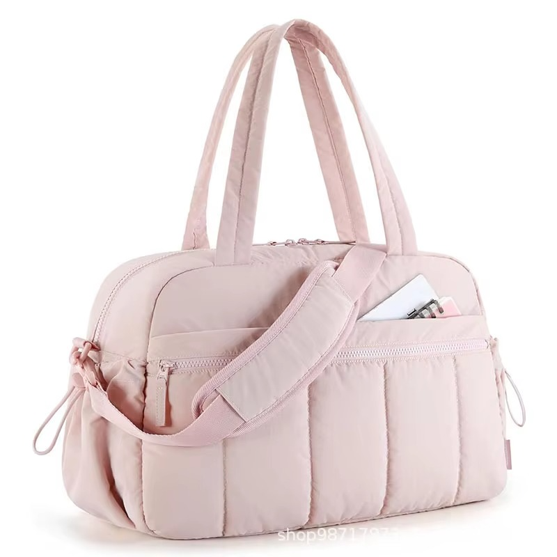 Pink waterproof diaper travel bag with shoulder strap and front zippered pocket.