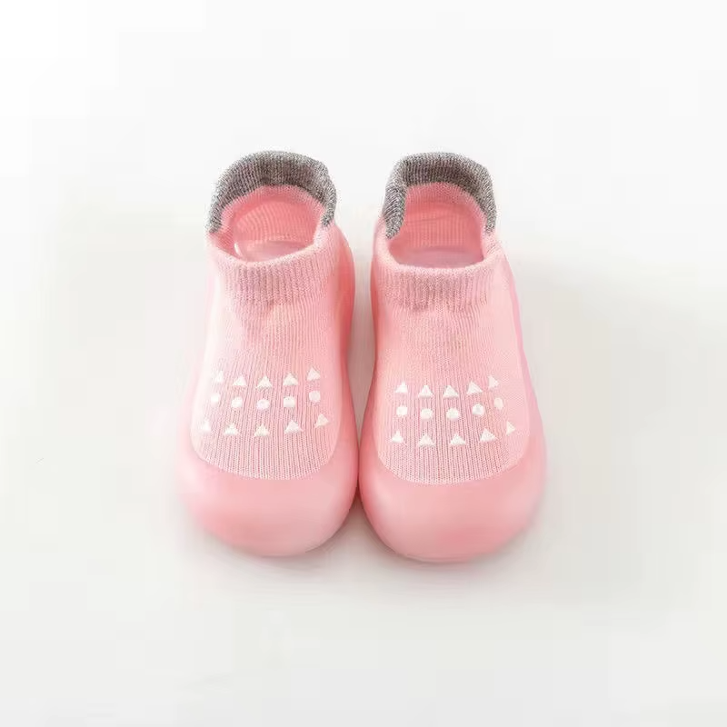Pink breathable baby walking shoes with soft sole and anti-slip pattern, top view.
