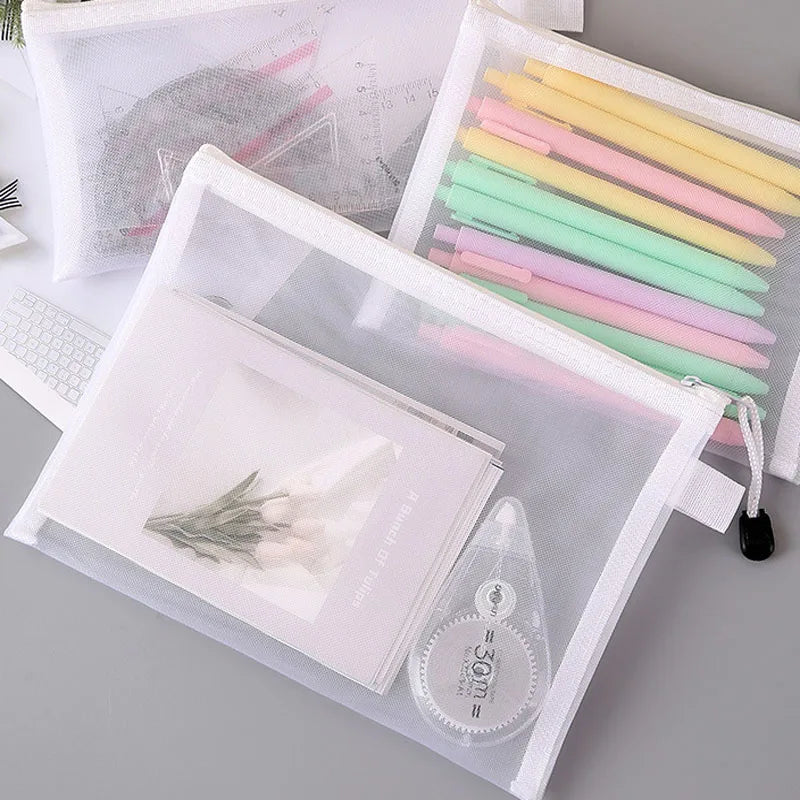 Three mesh zipper bags with pens, papers, and correction tape for organized storage.