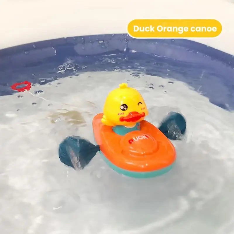 Orange duck kayak bath toy with blue paddles floating in water.