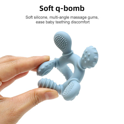 Hand squeezing blue silicone baby teething ring showing soft flexible texture and massage nubs.