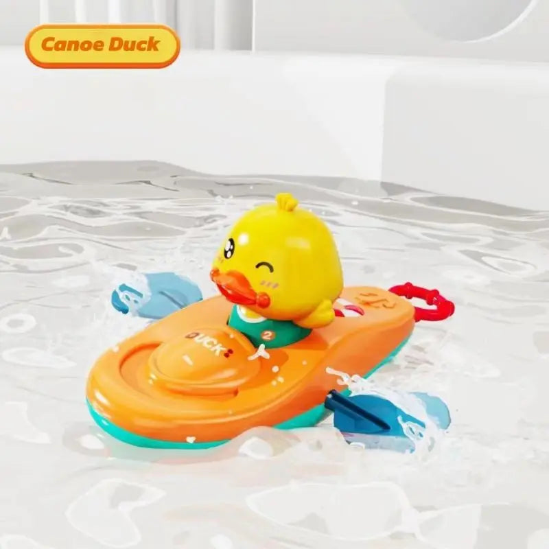 Yellow duck kayak bath toy floating in water with moving blue paddles.