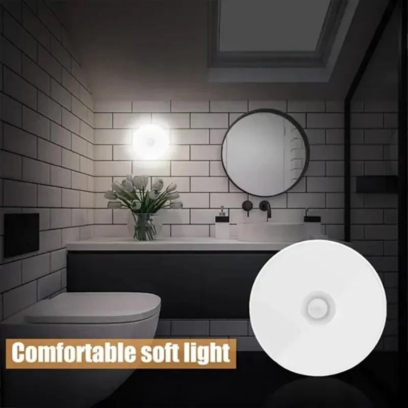 Motion sensor night light emitting soft white light mounted on bathroom wall above sink.