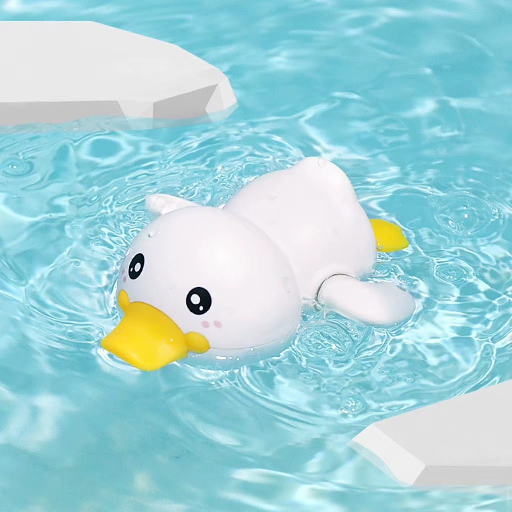 White duck wind-up bath toy floating in water with yellow beak and tail.