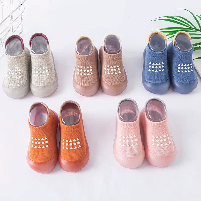 Variety of breathable baby walking shoes in multiple colors with soft soles and anti-slip patterns, arranged in rows.