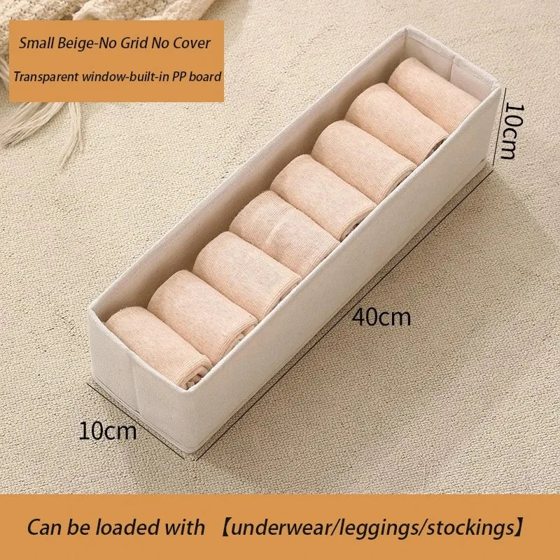 Small beige foldable fabric storage box with clear window for baby clothes organizer.
