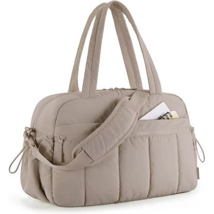 Beige waterproof diaper travel bag with shoulder strap and front and side pockets.