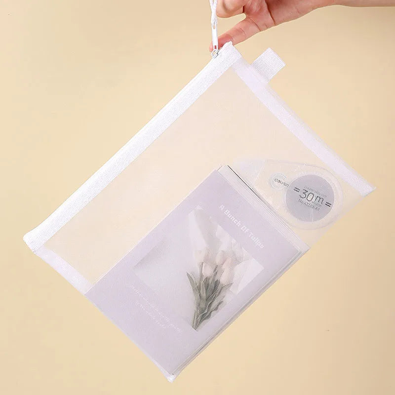 Close-up of hand holding zipper pull on white mesh zipper toy storage bag.
