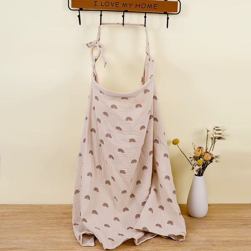 Beige breathable muslin nursing cover with brown rainbow print hanging with adjustable strap and ring, view 14.