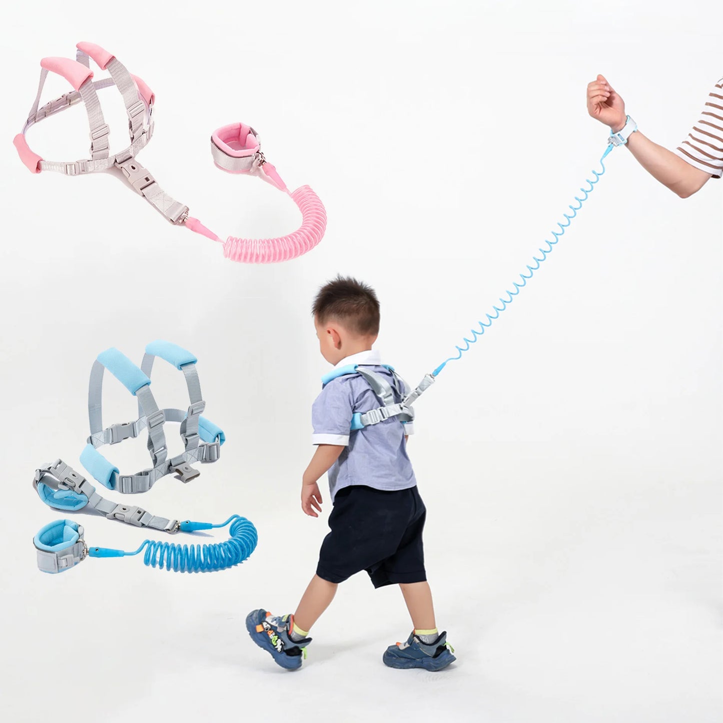 Toddler wearing blue anti-lost safety harness with spring leash wrist strap and pink harness set shown.