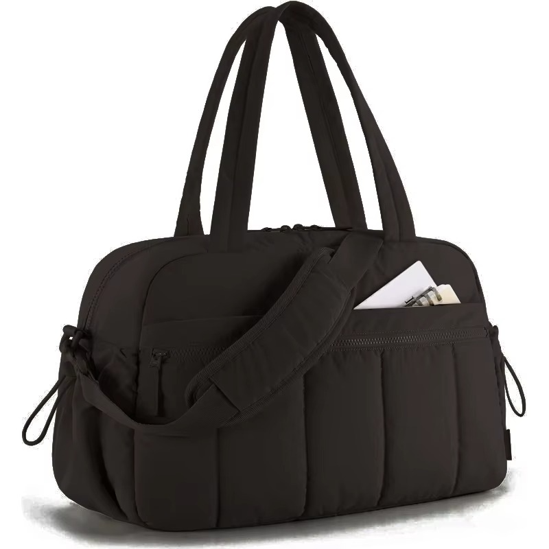 Black waterproof diaper travel bag with shoulder strap and front zippered pocket.