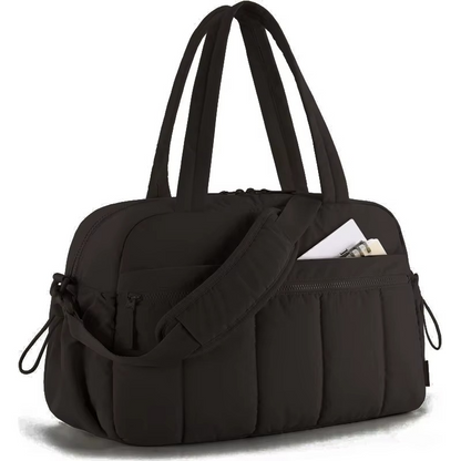 Black waterproof diaper travel bag with shoulder strap and front zippered pocket.