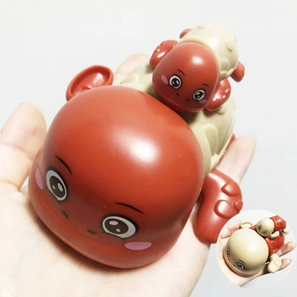 Red crab wind-up bath toy with smaller crab figure held in hand.