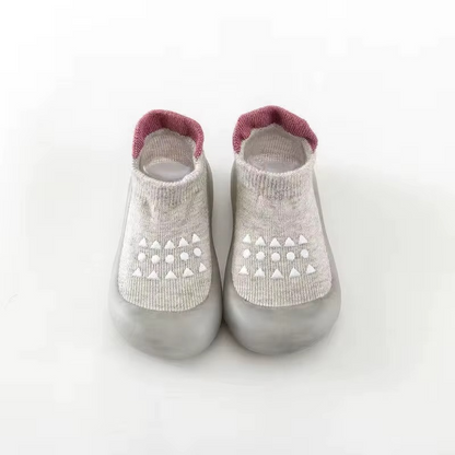 Grey breathable baby walking shoes with soft sole and white anti-slip pattern front view.
