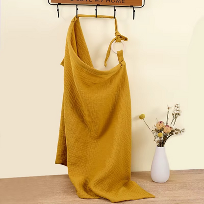 Khaki breathable muslin nursing cover hanging with adjustable strap and ring detail.