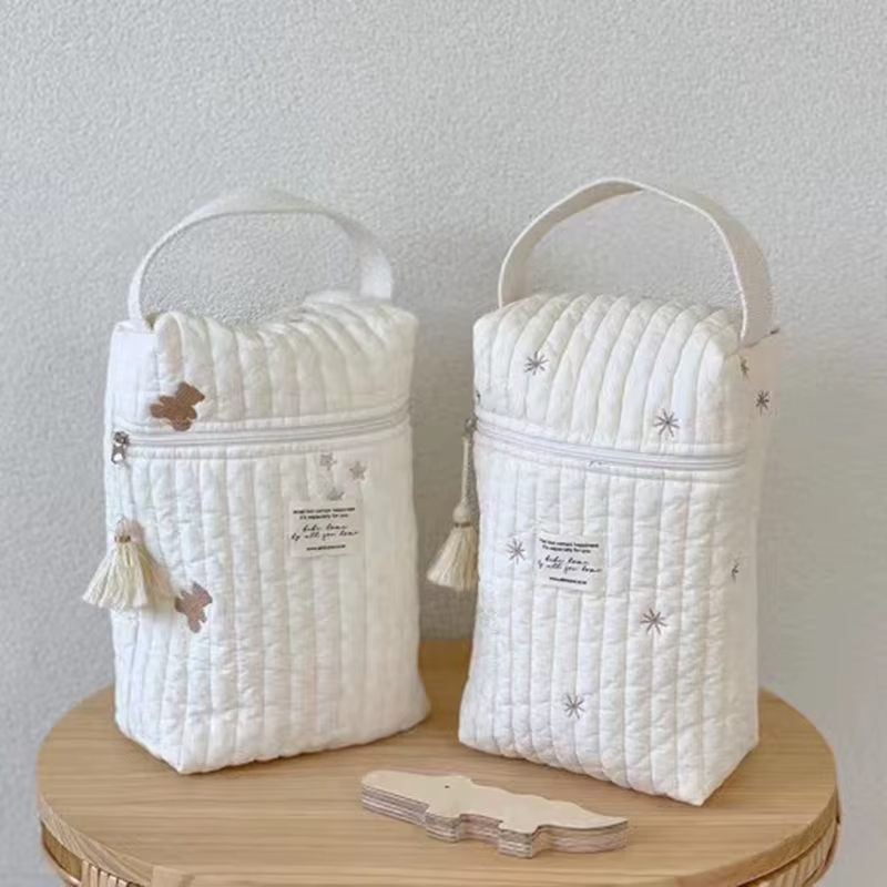 Quilted Diaper Caddy Bag Bear variant with tassel zipper pull on wooden table.