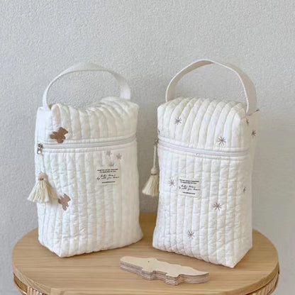 Quilted Diaper Caddy Bags in Bear and Snowflake embroidery designs on wooden table.