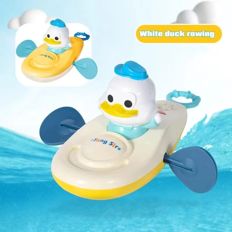 White duck on white and yellow kayak bath toy with blue paddles and pull cord.