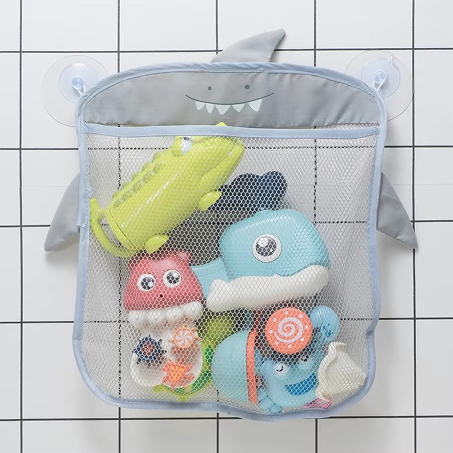 Gray shark-themed baby bath toy storage mesh bag with suction cups filled with bath toys.