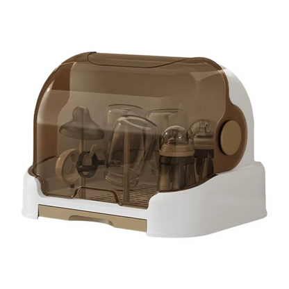 White baby bottle drying rack with closed brown lid holding baby bottles and accessories.