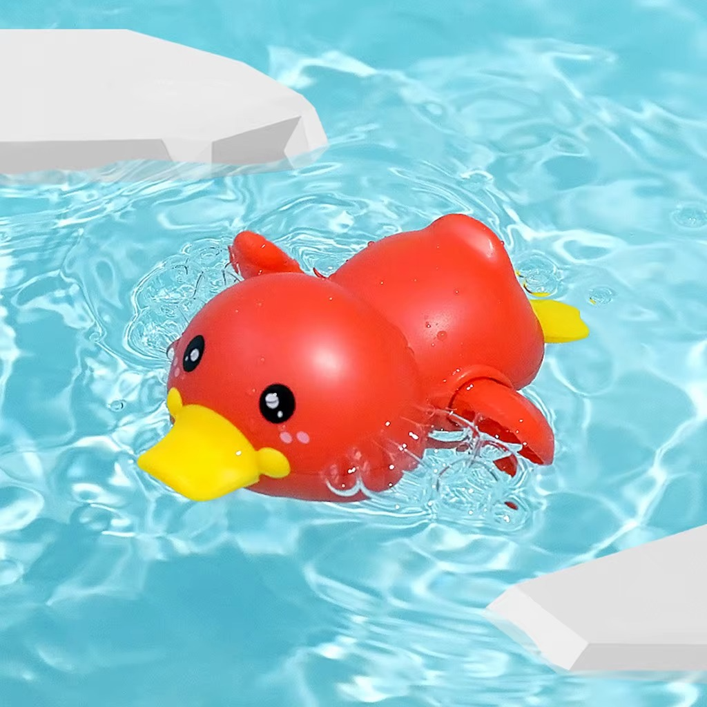 Red duck wind-up bath toy floating in water with yellow beak and tail.