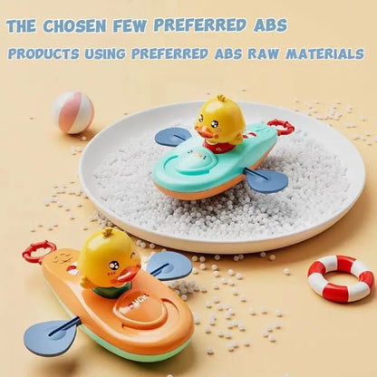Two wind-up duck kayak bath toys in orange and blue on white beads with bath accessories.