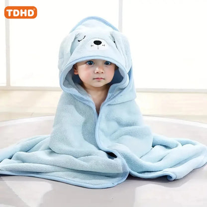 Baby wrapped in light blue dog animal hooded baby bath towel with embroidered face and floppy ears sitting on floor, view 8.