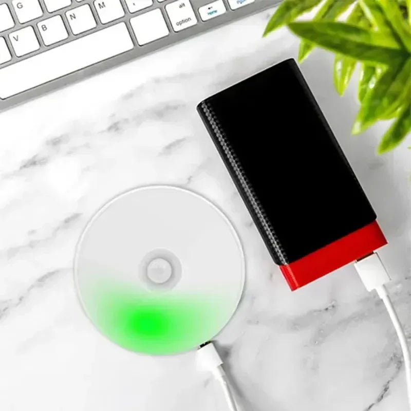 Rechargeable night light plugged into USB power bank showing charging indicator light.