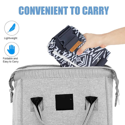 Folded patterned adjustable baby carrier wrap being placed into gray carrying bag.