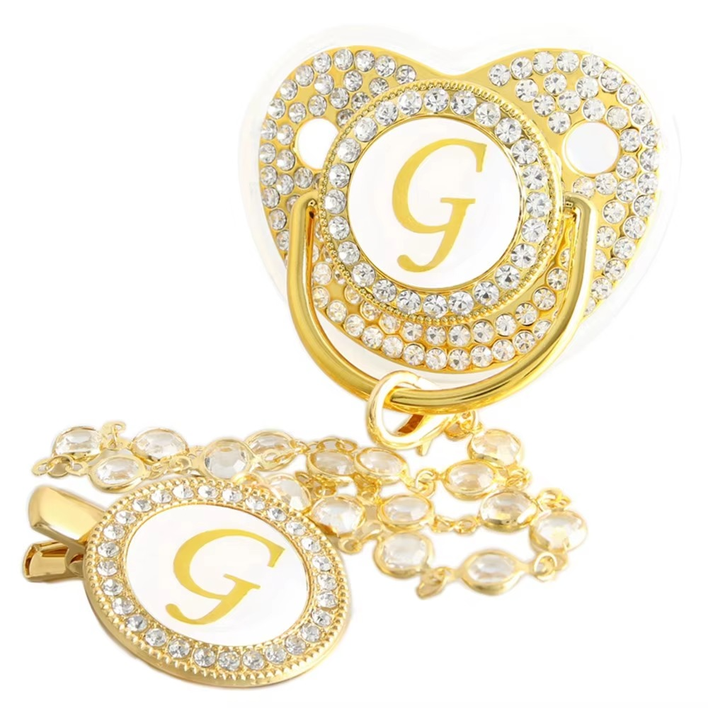 Personalized white and gold baby pacifier with letter G and crystal clip chain.