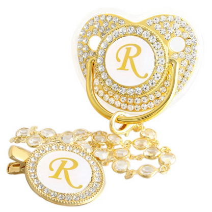 Personalized gold baby pacifier and crystal clip chain with letter R initial.