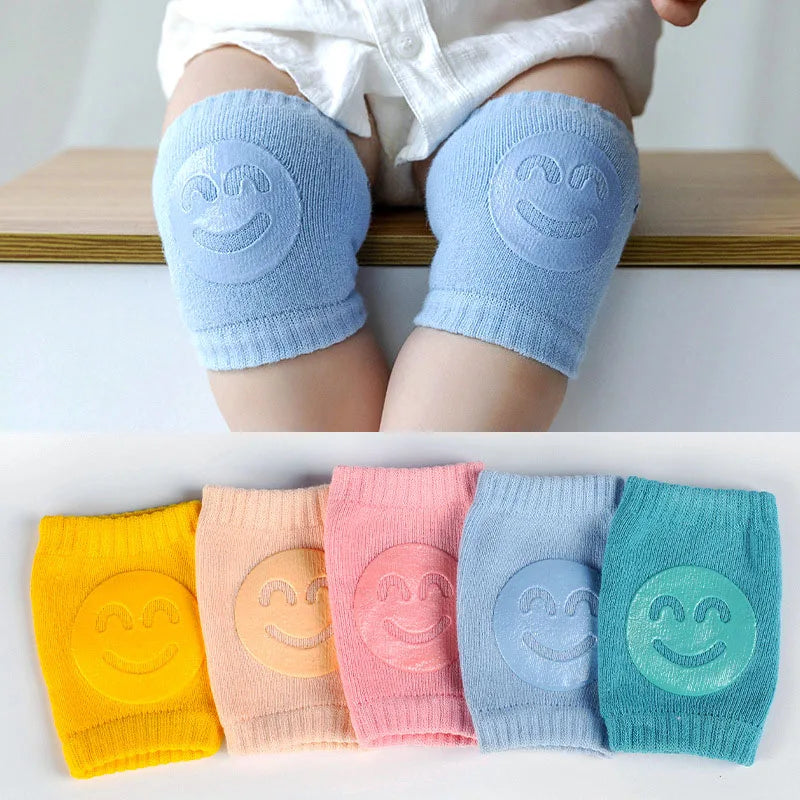 Comfort Crawl baby knee pads in light blue on baby knees with smiley grip pads.